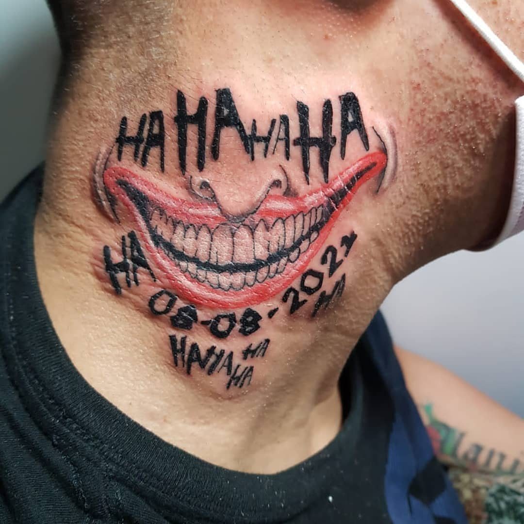 Creepy red smile tattoo with white teeth and laughter text on a neck.