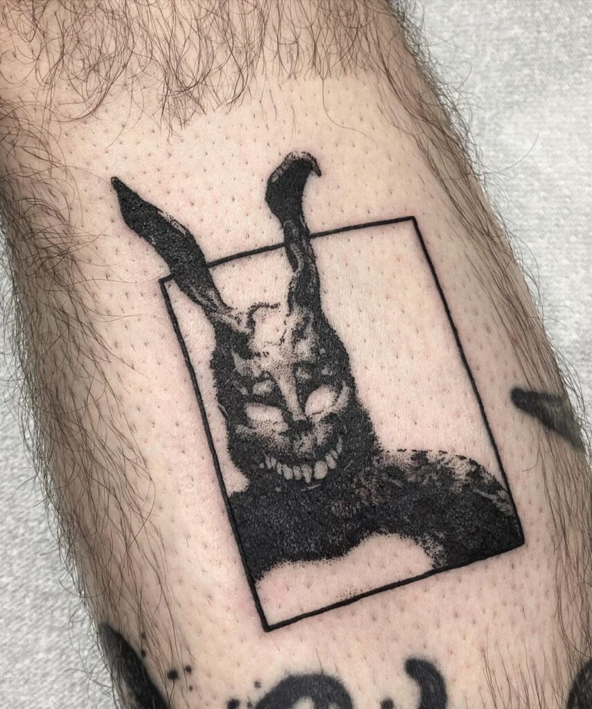 Donnie Darko Frank the rabbit tattoo on a person's leg in black ink