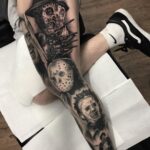 Freddy Krueger and other horror movie characters tattooed in black and grey on a leg