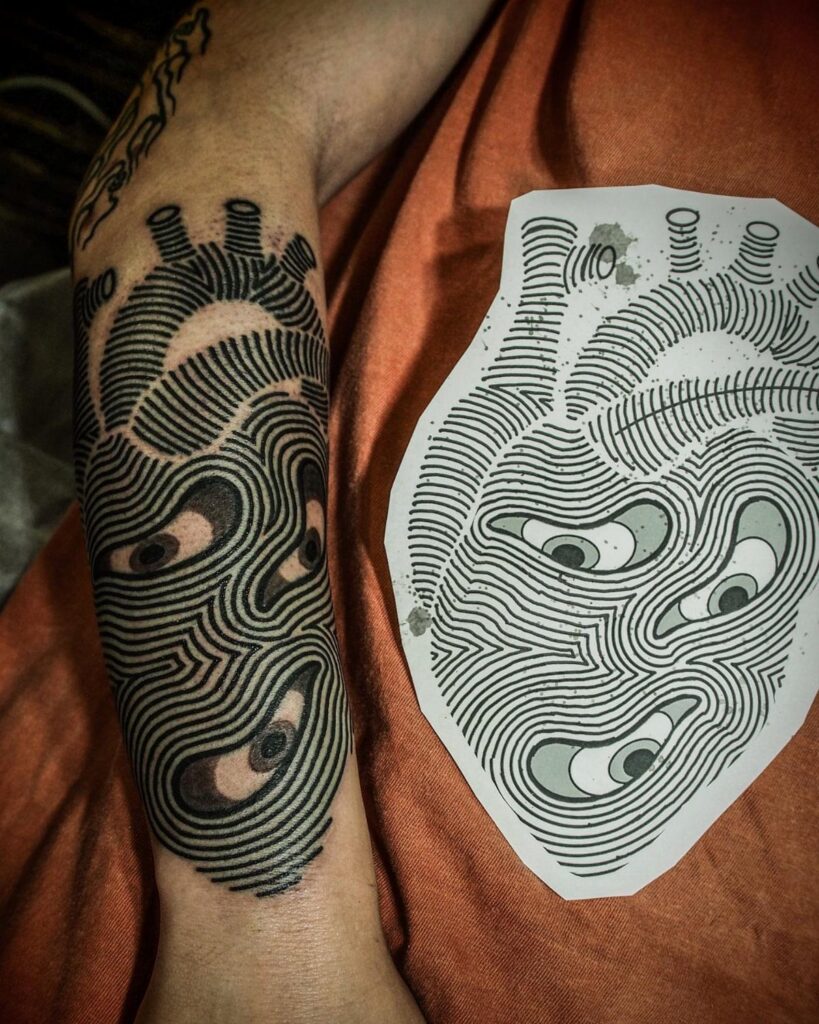 Black ink heart tattoo with multiple eyes and optical illusion lines on a forearm