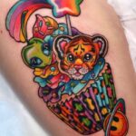 Colorful tattoo of a tiger cub in a rainbow cupcake with a smiley planet.