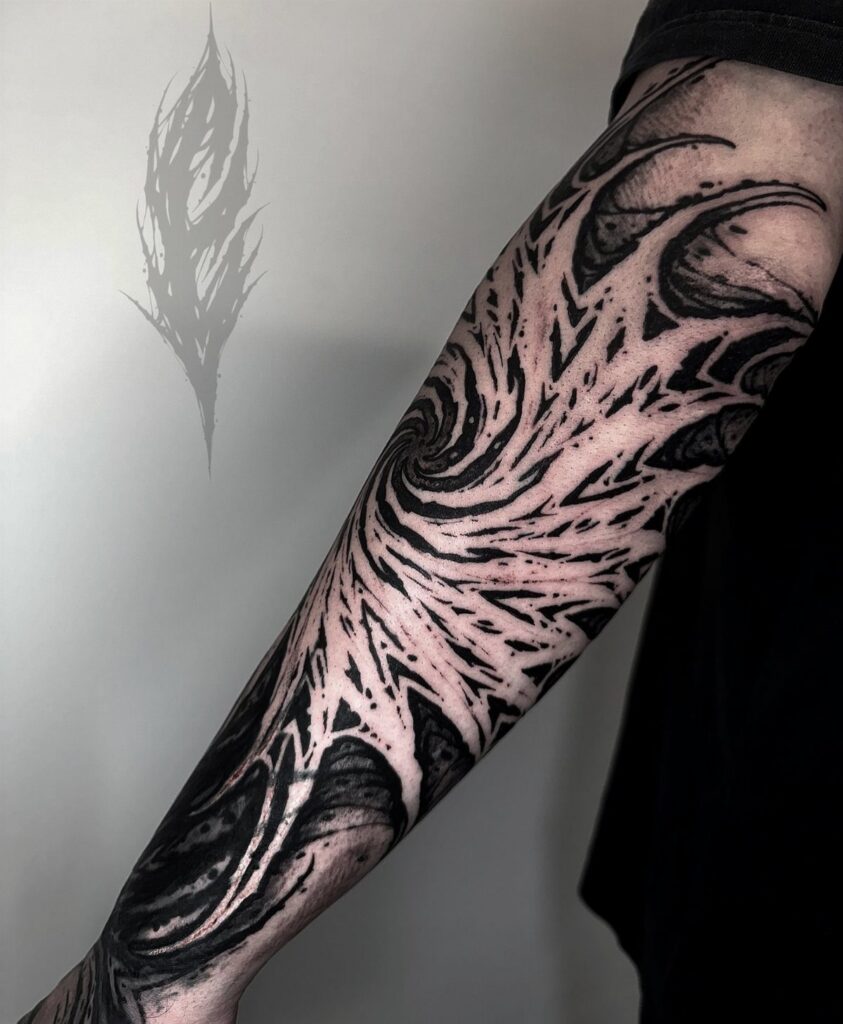 Black ink tattoo on an arm using negative space to create swirling patterns