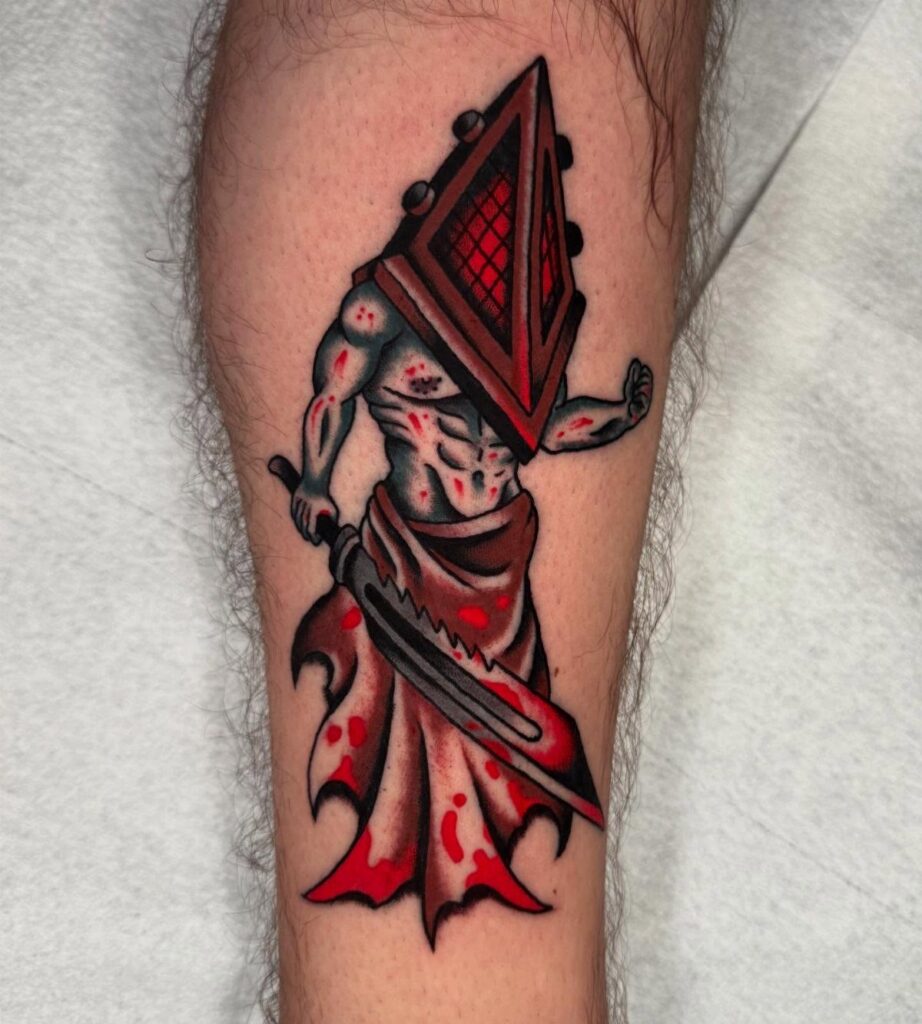 Pyramid Head tattoo on a leg featuring a red helmet and large blade.