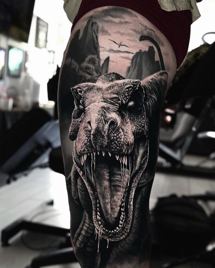 T-Rex tattoo on a leg featuring a roaring dinosaur and prehistoric landscape.