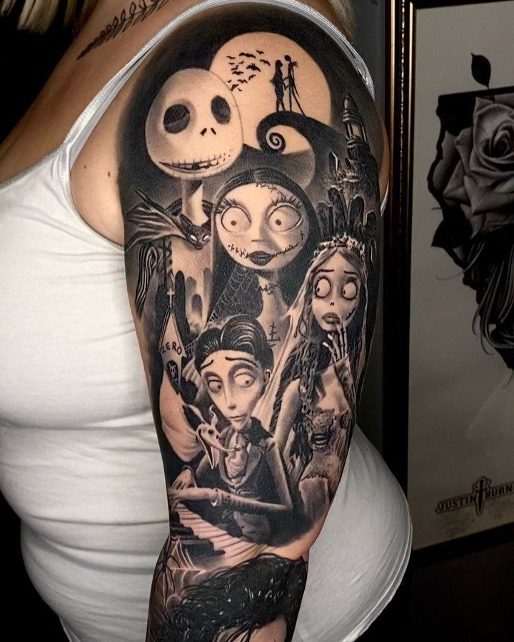Black and grey arm tattoo featuring various Tim Burton movie characters and scenery.