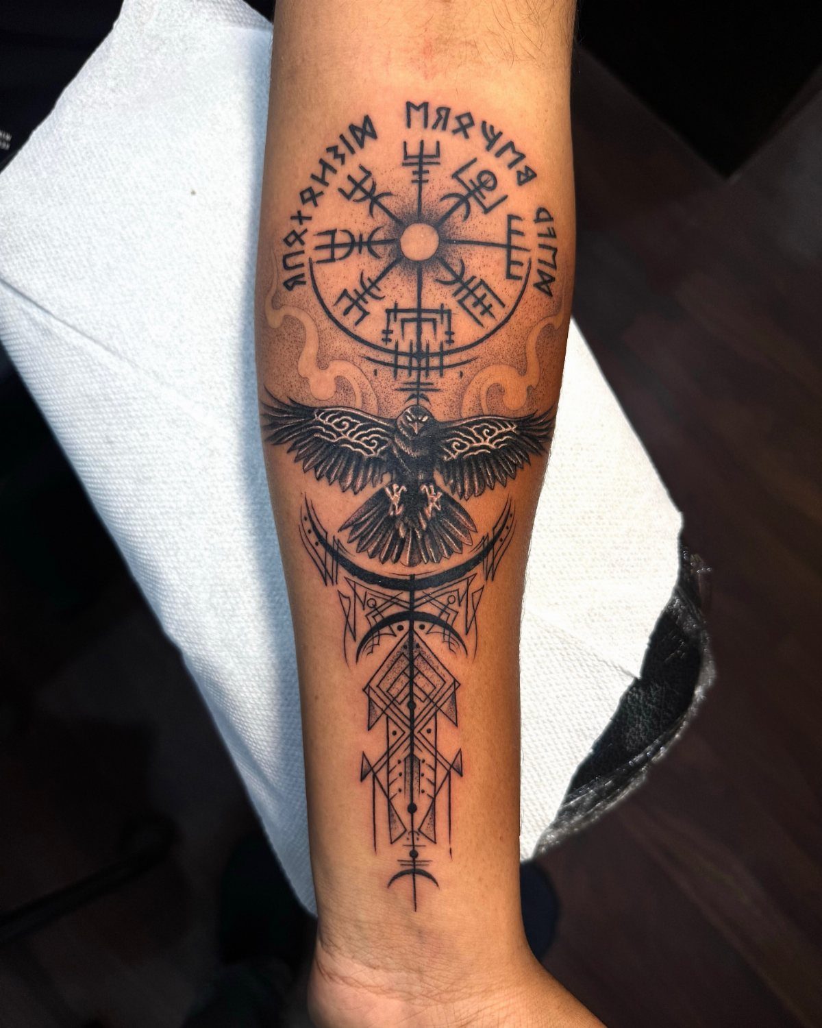 Viking compass tattoo on a forearm with an eagle and runic symbols